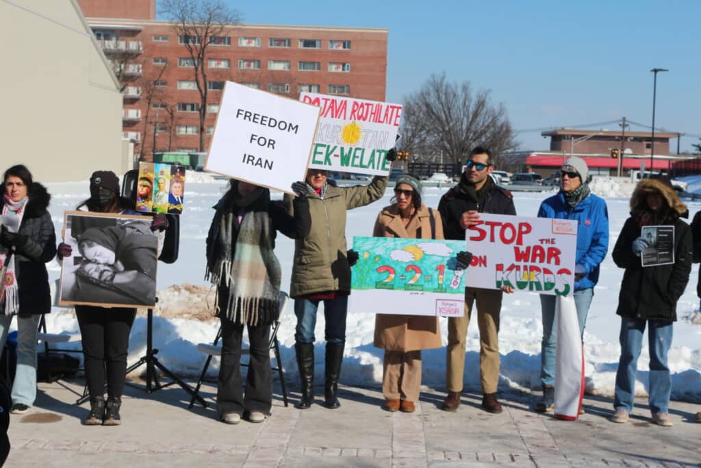 Demonstrators hold signs rejecting Iranian regime